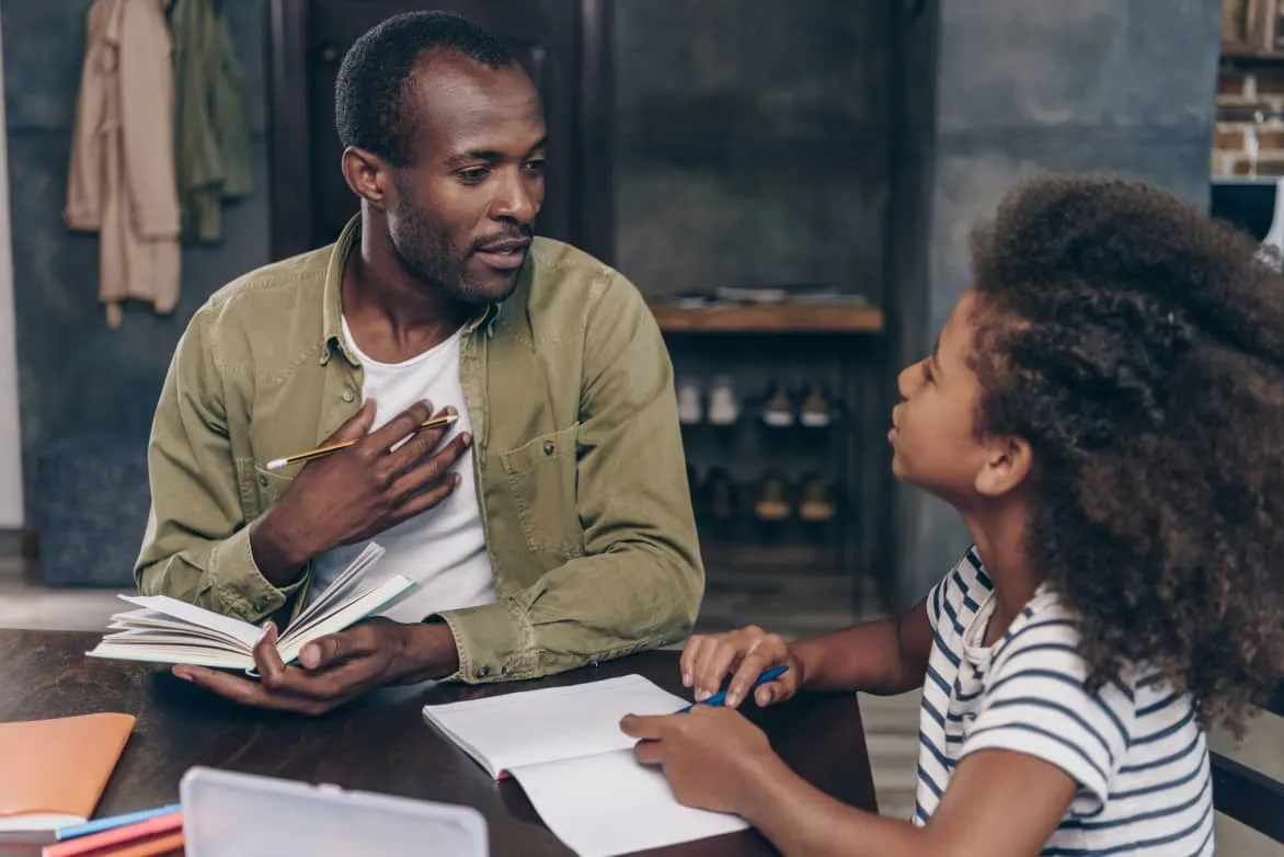 A child learning at home with crayons and a notebook